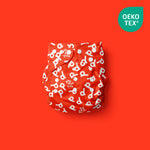 Descubre el increíble modelo de pañal reutilizable What a Poo con color divertido y motivos de nuestro logo extraordinario Poo Poo Tras - en fondo rojo