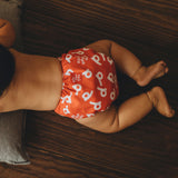 El pañal ecológico reutilizable What a Poo - un modelo elegante llevado por un bebé acostado