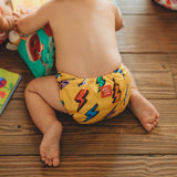 Panal lavable para bebé llamativo y elegante Poo and flashy - llevado por un bebé y jugando con niños